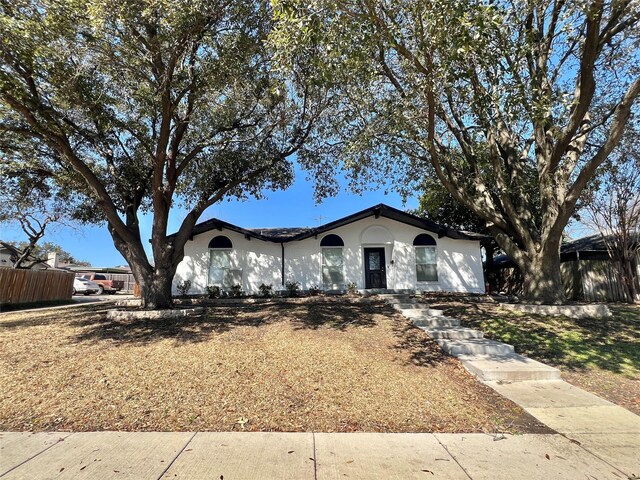 single story home with stucco siding and fence