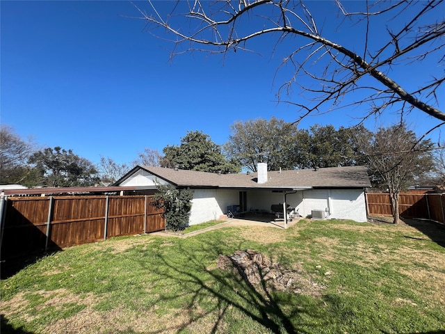 rear view of property featuring central AC unit, a lawn, a chimney, a fenced backyard, and a patio area