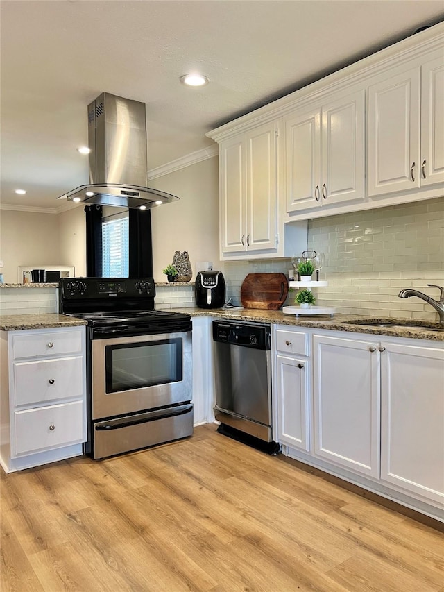 kitchen with ornamental molding, a sink, white cabinetry, stainless steel appliances, and island range hood