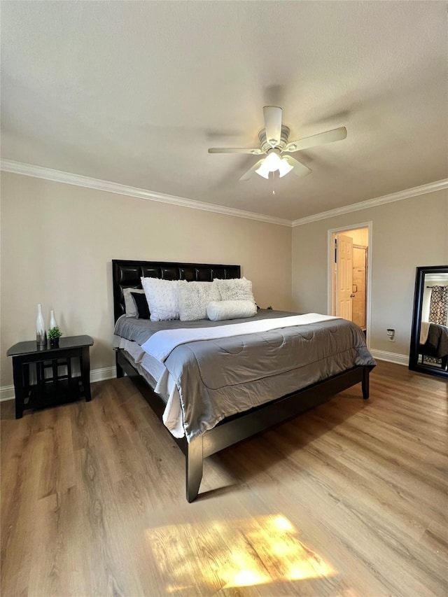 bedroom featuring crown molding, wood finished floors, baseboards, and ceiling fan