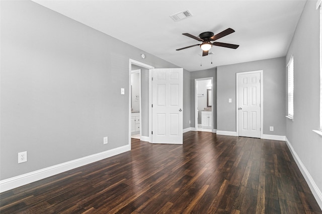 empty room featuring visible vents, baseboards, dark wood-style flooring, and a ceiling fan