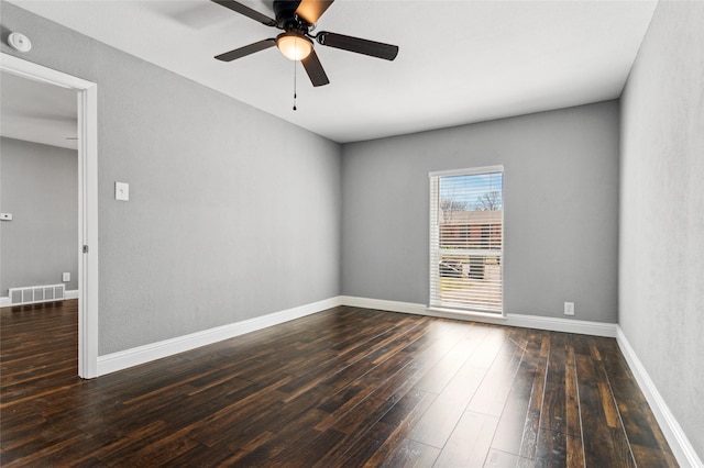 empty room with dark wood finished floors, baseboards, visible vents, and ceiling fan