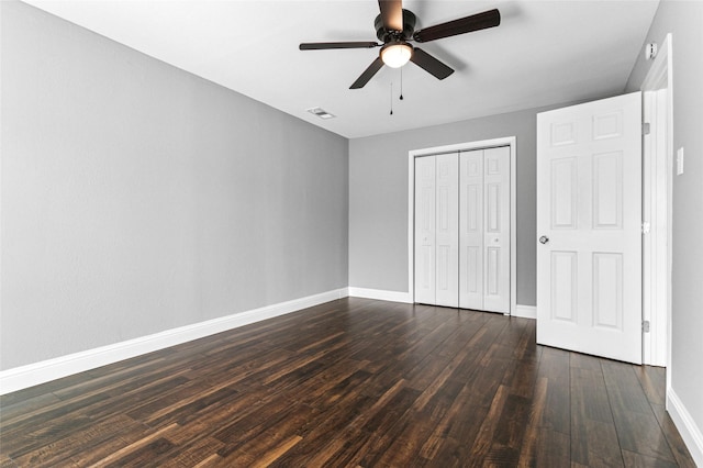 unfurnished bedroom with visible vents, baseboards, dark wood finished floors, a closet, and a ceiling fan