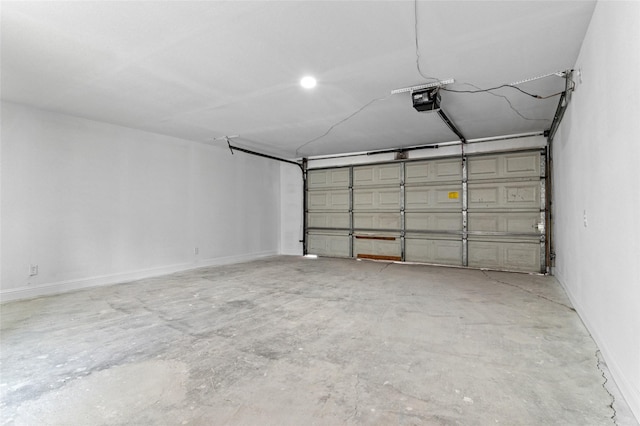 garage featuring a garage door opener and baseboards