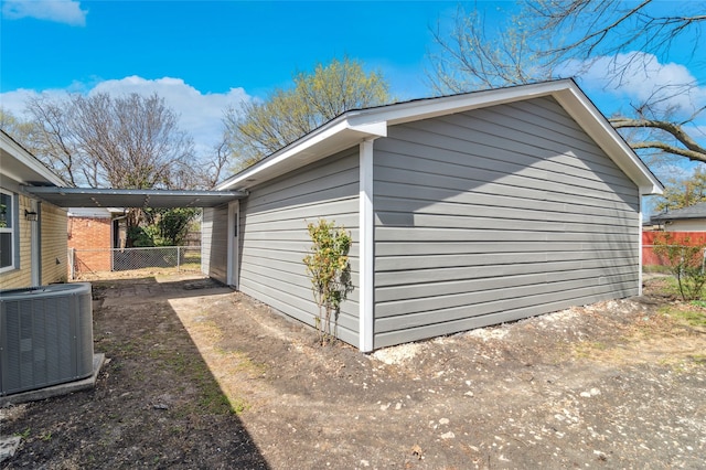 view of side of property featuring central AC unit and fence