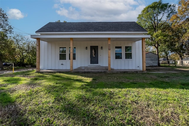 view of front of property with a porch, board and batten siding, a shingled roof, and a front yard