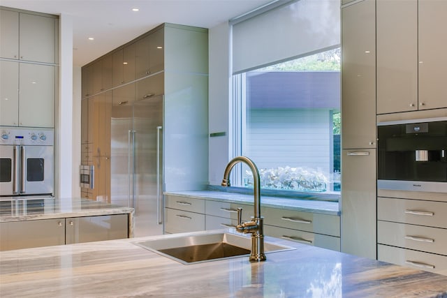 kitchen with a sink, stainless steel appliances, modern cabinets, and gray cabinets