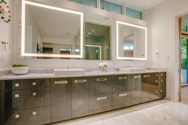 bathroom with double vanity, marble finish floor, and a sink