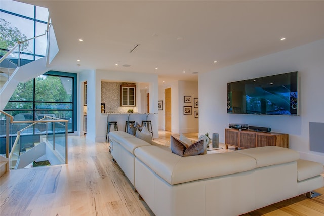 living room with stairs, recessed lighting, and light wood finished floors