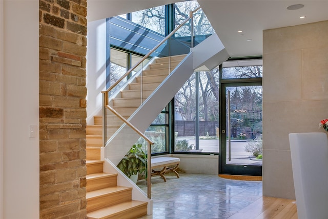 stairs featuring plenty of natural light and a towering ceiling