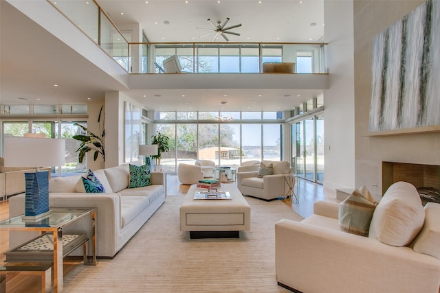 living area with a high ceiling, recessed lighting, a healthy amount of sunlight, and expansive windows