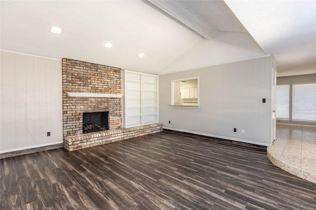 unfurnished living room with lofted ceiling with beams, baseboards, a brick fireplace, and wood finished floors