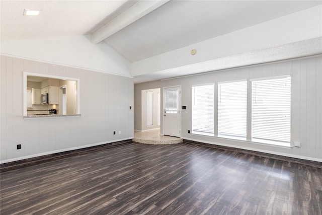 unfurnished living room with baseboards, dark wood finished floors, and vaulted ceiling with beams