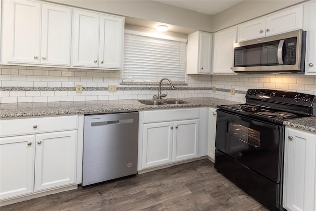 kitchen with a sink, appliances with stainless steel finishes, dark wood-style floors, and white cabinetry