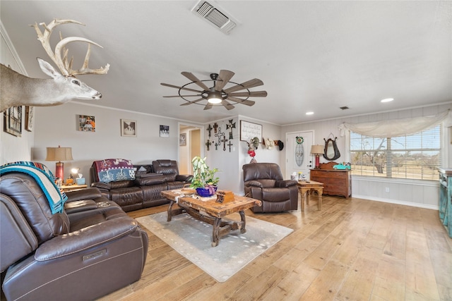 living area featuring ceiling fan, visible vents, light wood-style flooring, and ornamental molding