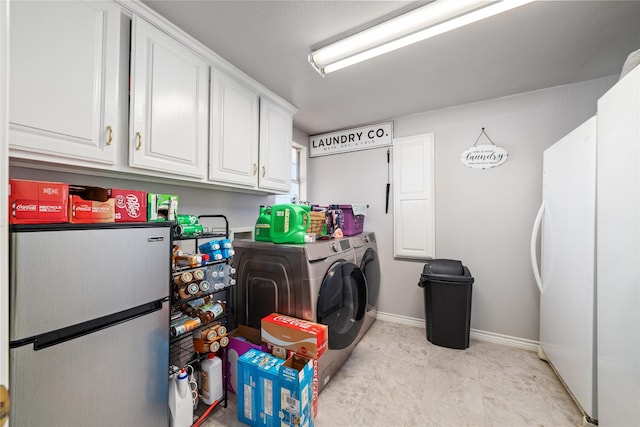 washroom with baseboards, cabinet space, and independent washer and dryer