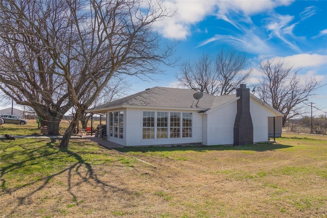 rear view of property with a yard and a chimney