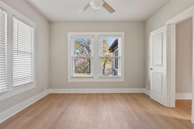 empty room featuring baseboards, light wood-style floors, and a ceiling fan