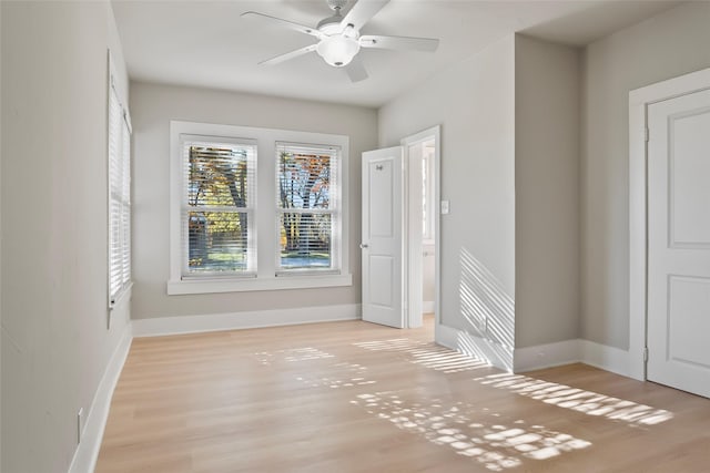 spare room with light wood-style floors, baseboards, and ceiling fan