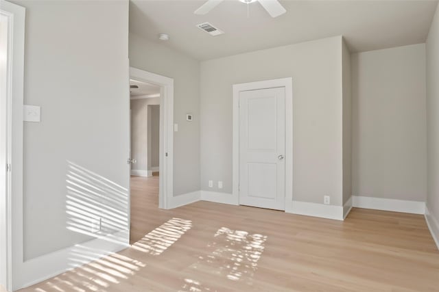 unfurnished room with ceiling fan, visible vents, baseboards, and wood finished floors