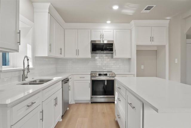 kitchen with a sink, light countertops, visible vents, and stainless steel appliances