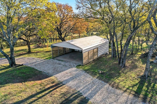 view of pole building featuring gravel driveway and a yard