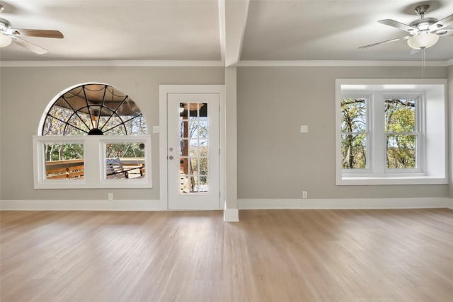 entryway with light wood-style flooring, a ceiling fan, crown molding, and baseboards