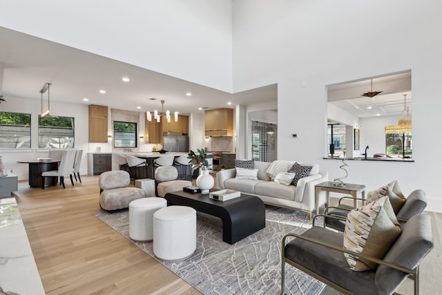 living room with a chandelier, recessed lighting, and light wood-type flooring