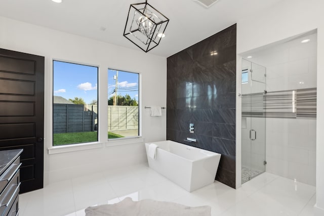 full bath featuring a freestanding tub, a stall shower, recessed lighting, an inviting chandelier, and vanity