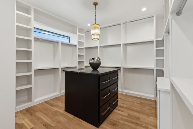 walk in closet with light wood-style floors