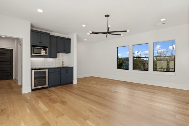 kitchen featuring visible vents, tasteful backsplash, wine cooler, light wood-style floors, and built in microwave