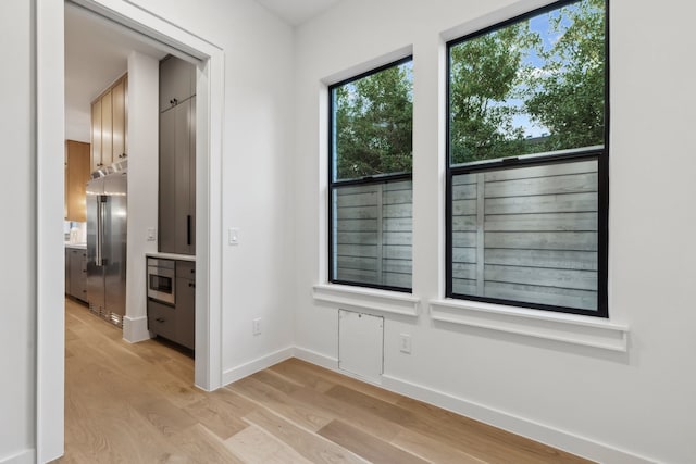 unfurnished room featuring light wood-type flooring and baseboards