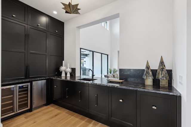 bar with a sink, fridge, wine cooler, and light wood finished floors