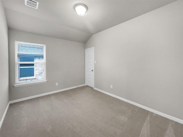 unfurnished room with visible vents, baseboards, lofted ceiling, and carpet flooring