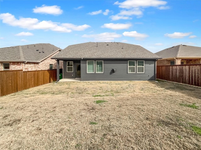 back of property featuring a lawn, a patio, a fenced backyard, and roof with shingles