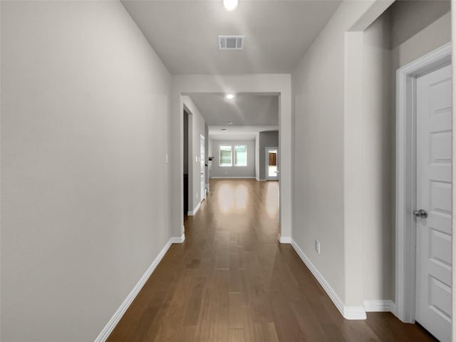 hall with recessed lighting, visible vents, baseboards, and dark wood-type flooring