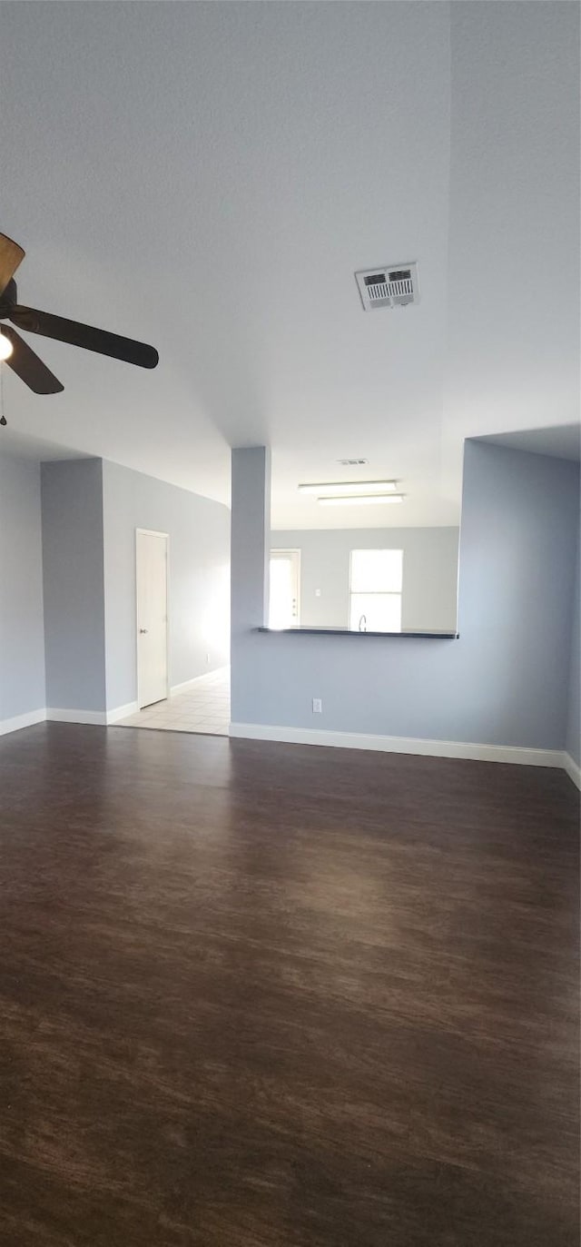 empty room featuring visible vents, baseboards, ceiling fan, and wood finished floors