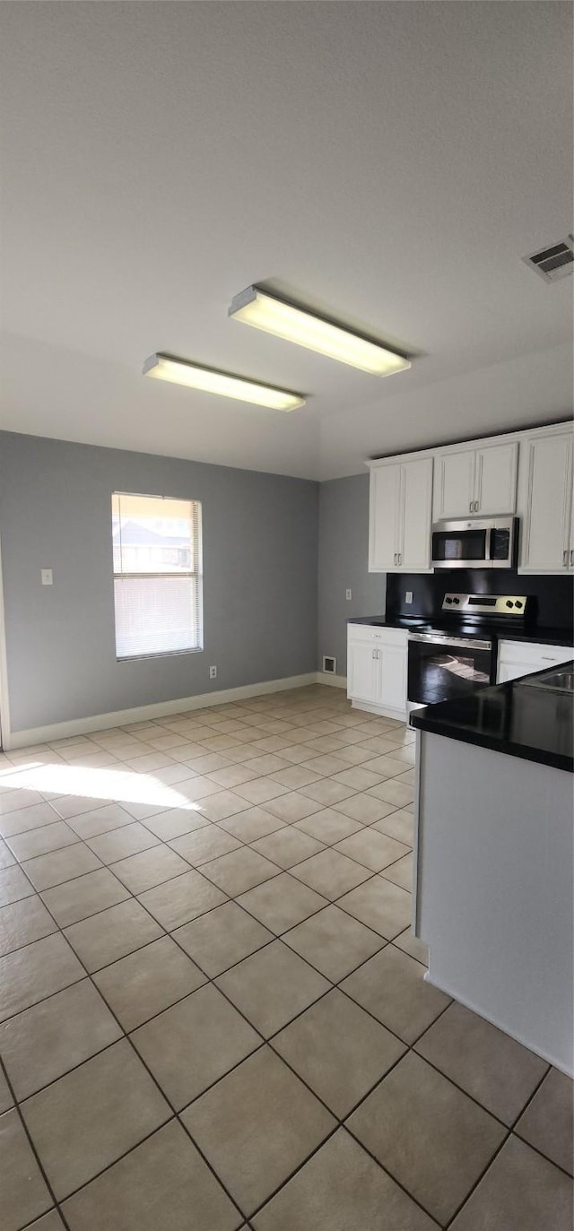 kitchen featuring light tile patterned floors, white cabinetry, and stainless steel appliances