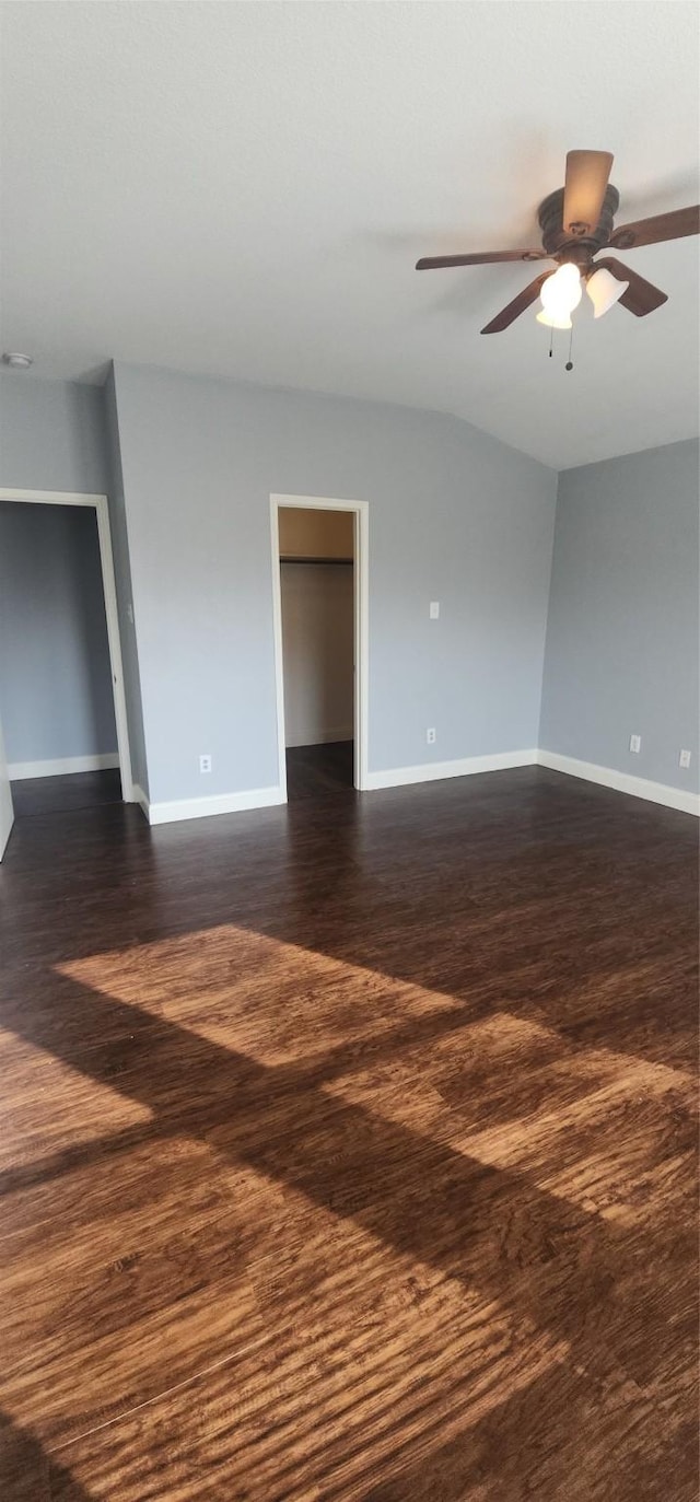 empty room with dark wood finished floors, baseboards, and ceiling fan