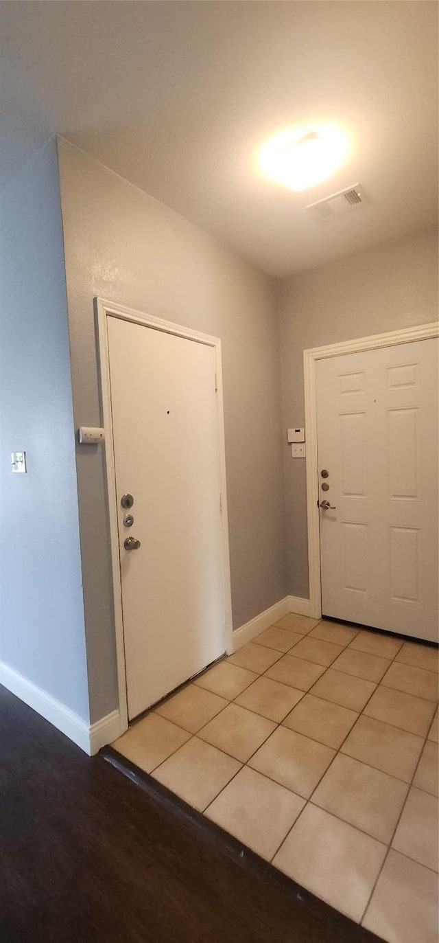 entryway featuring light tile patterned floors, visible vents, and baseboards