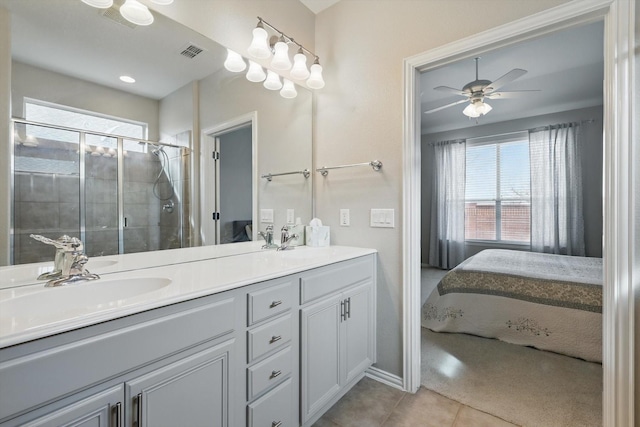 bathroom featuring visible vents, double vanity, a stall shower, a sink, and tile patterned floors