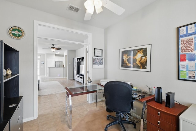 office with light tile patterned floors, visible vents, baseboards, and a ceiling fan