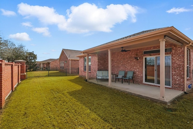 rear view of property featuring a yard, a patio area, brick siding, and ceiling fan