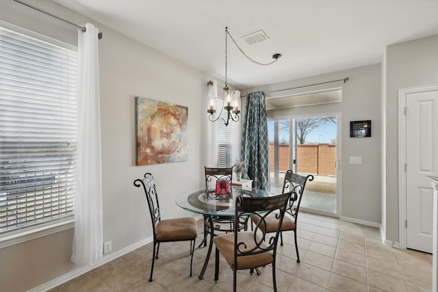 dining space with a chandelier, light tile patterned floors, baseboards, and visible vents