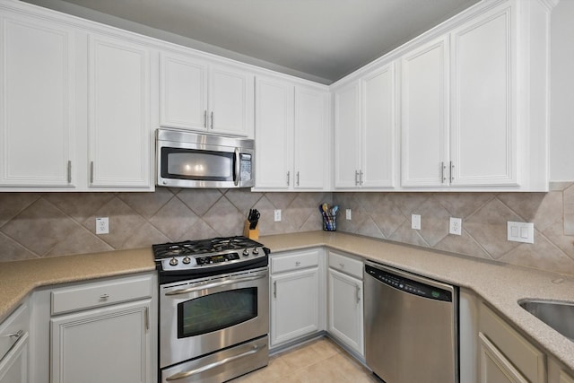 kitchen featuring decorative backsplash, white cabinetry, and appliances with stainless steel finishes