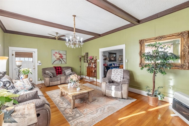 living area featuring beamed ceiling, plenty of natural light, a textured ceiling, and wood finished floors