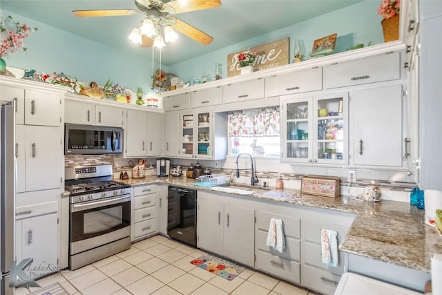 kitchen featuring a sink, light tile patterned floors, white cabinetry, and stainless steel appliances