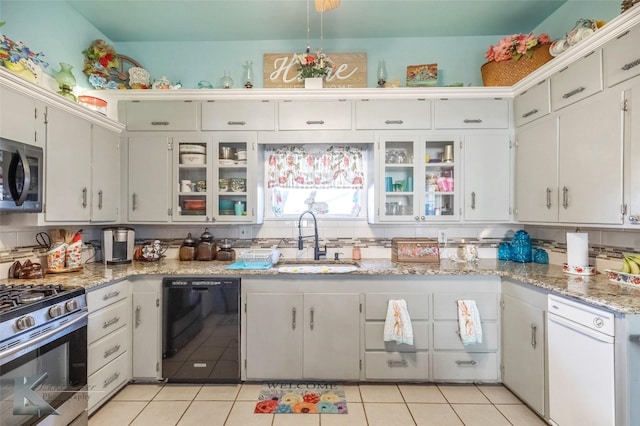 kitchen with a sink, stainless steel appliances, backsplash, and light tile patterned flooring