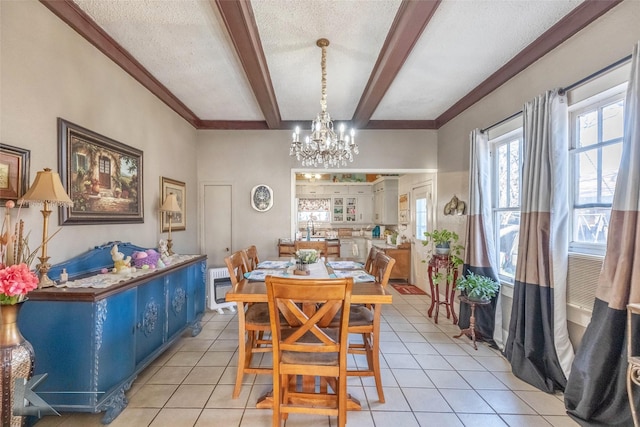 dining room featuring an inviting chandelier, beam ceiling, light tile patterned floors, and a textured ceiling