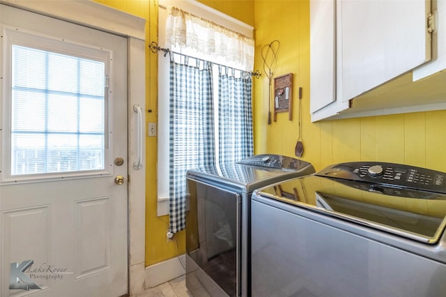 clothes washing area featuring light tile patterned flooring, cabinet space, and independent washer and dryer